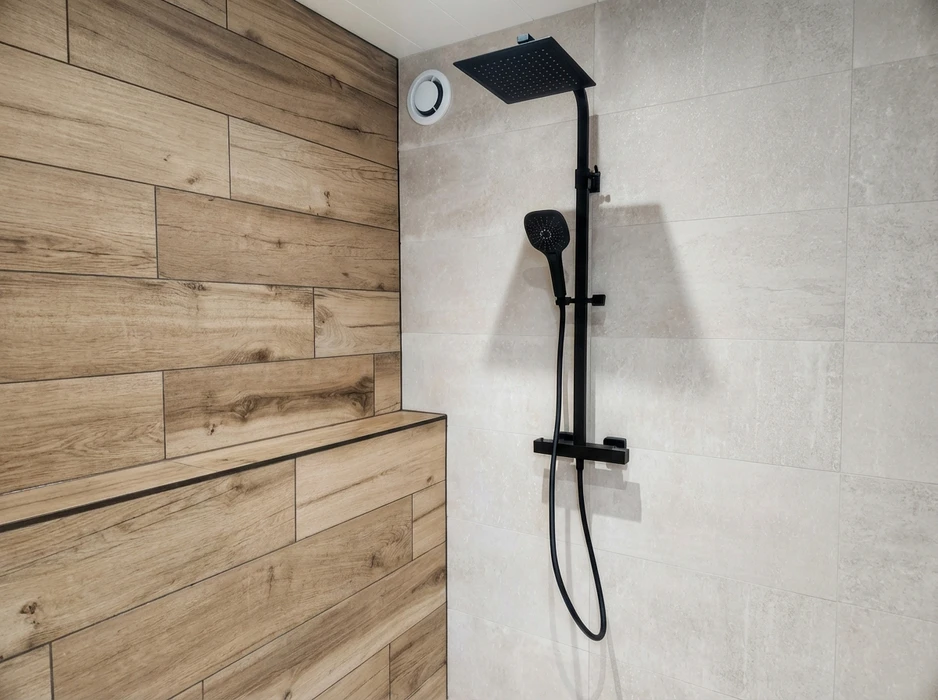 Salle de bain moderne avec baignoire îlot blanche semi-adossée au mur, robinetterie noire mate, sol et mur en carrelage imitation bois