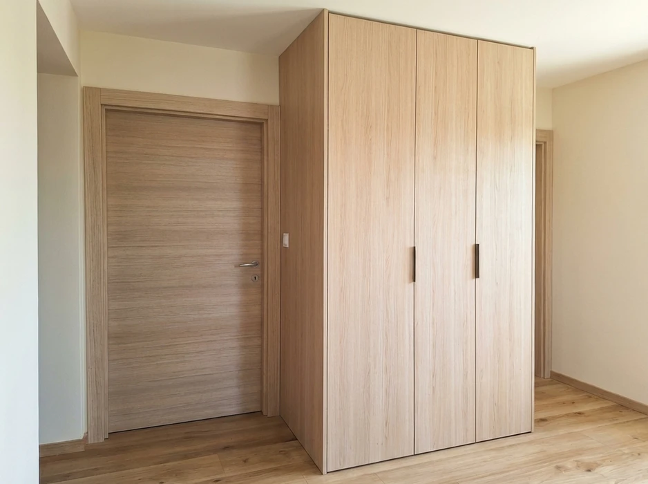 Entrée moderne avec porte d'entrée beige à insert vitrés géométriques, encadrée par une fenêtre latérale fixe