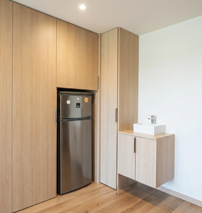 Cuisine moderne en L avec façades bois clair chêne naturel, plan de travail et crédence en marbre noir veiné blanc
