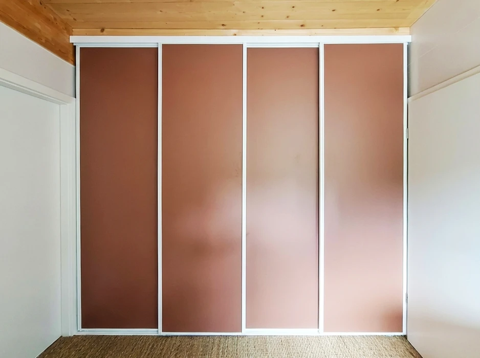 Intérieur résidentiel, cage d'escalier visible depuis un couloir à travers une porte ouverte