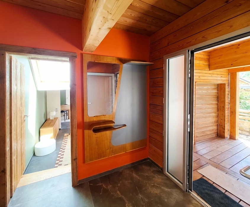 Photographie professionnelle d'une salle de bain rénovée moderne avec baignoire encastrée, carrelage mural de qualité, meuble vasque sur mesure en bois, miroir éclairant et finitions contemporaines, illustrant l'expertise en rénovation de salles de bain de Seigne Cuisines et Habitat.