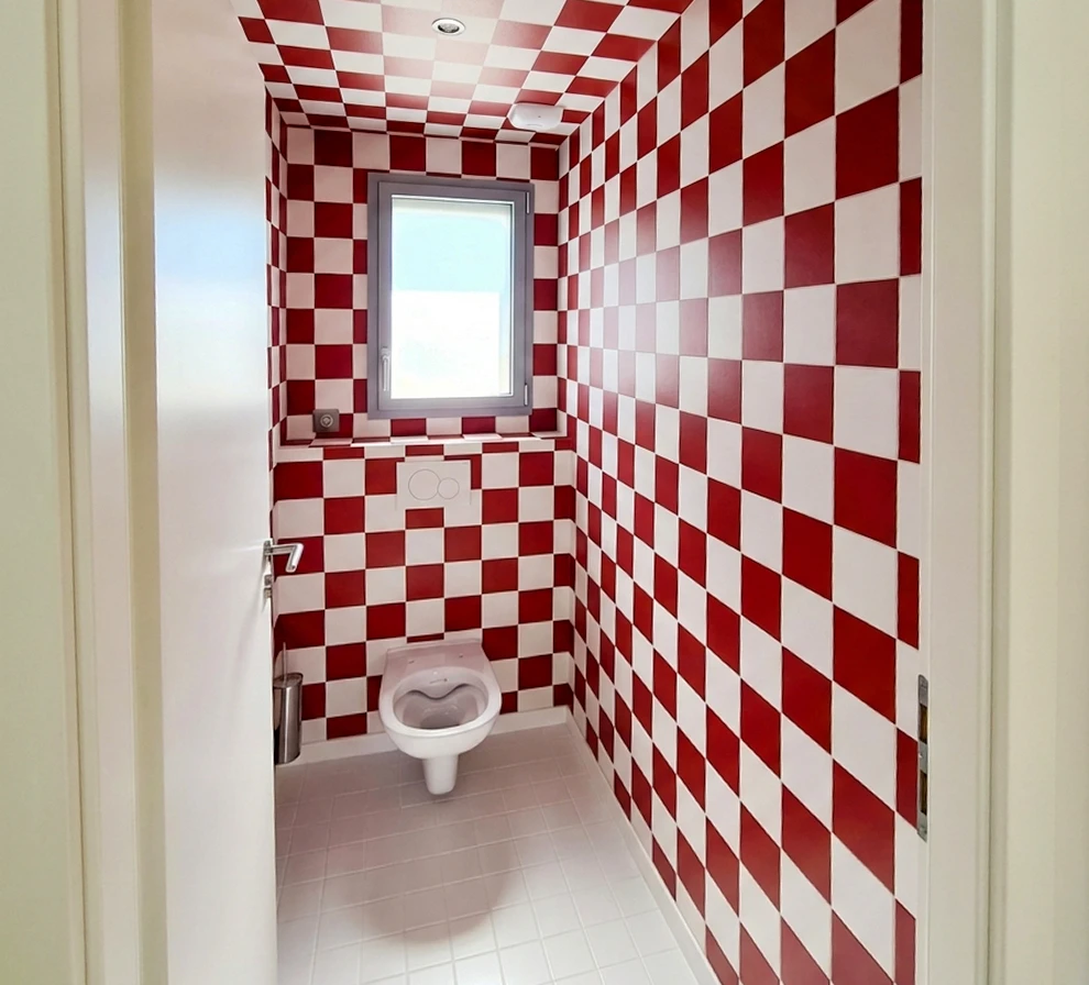 Salle de bain moderne avec baignoire îlot blanche semi-adossée au mur, robinetterie noire mate, sol et mur en carrelage imitation bois