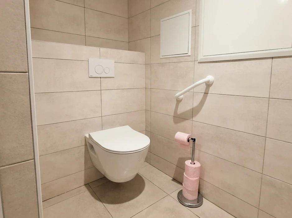 Salle de bain moderne avec douche à l'italienne, murs en béton brut style industriel