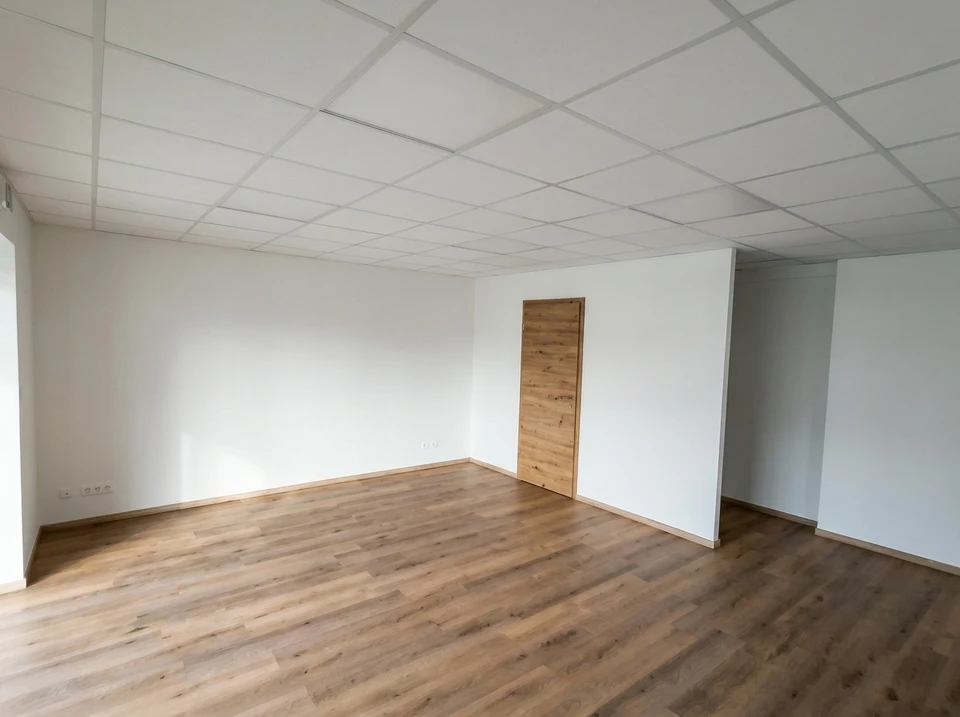 Chantier de pose de parquet en cours dans une pièce aux murs abîmés